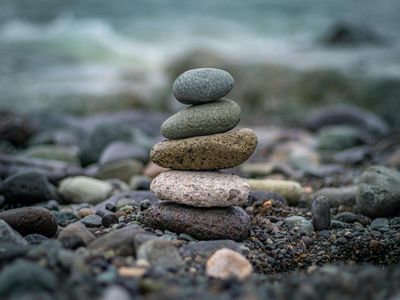 Smooth stones stacked perfectly on a serene beach.