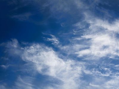 Wide view of a clear blue sky with a few wispy clouds.